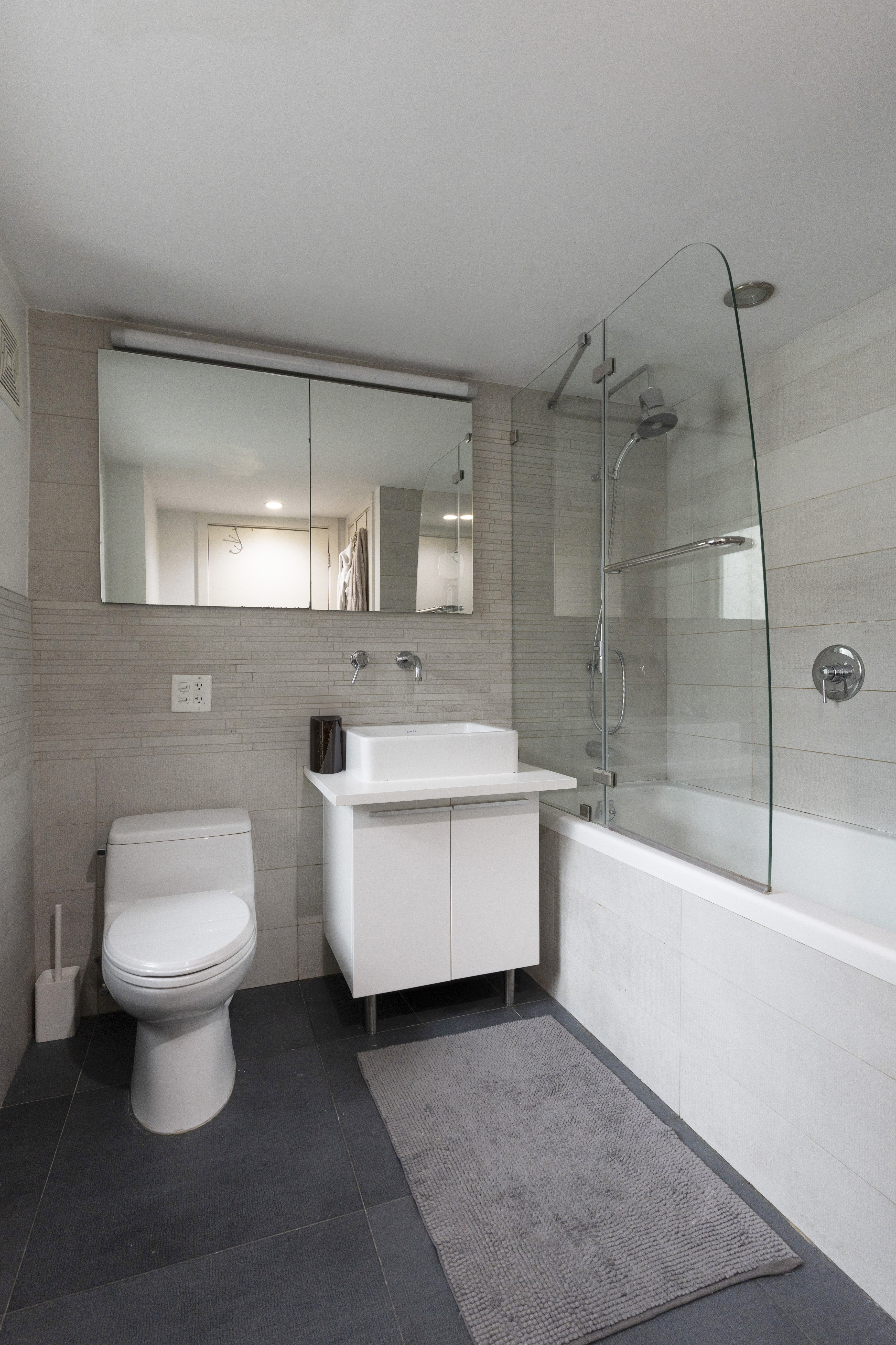 390 Lorimer Street, Unit 3H Brooklyn, NY 11206 - Photo 4 of 13 a bathroom with a sink toilet a mirror and bathtub