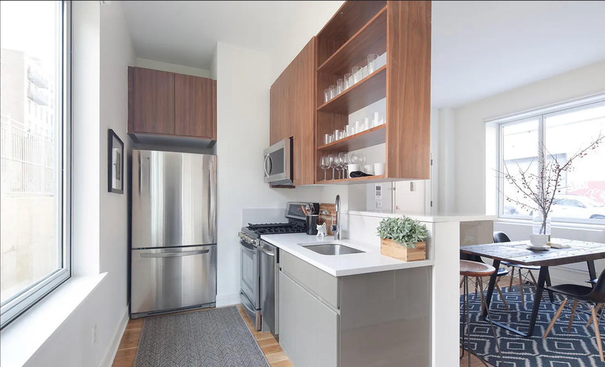 224 Wythe Avenue, Unit 72B Brooklyn, NY 11249 - Photo 3 of 6 a kitchen with a refrigerator a stove a sink and a dining table