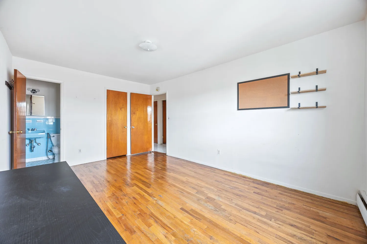 a view of an empty room with wooden floor