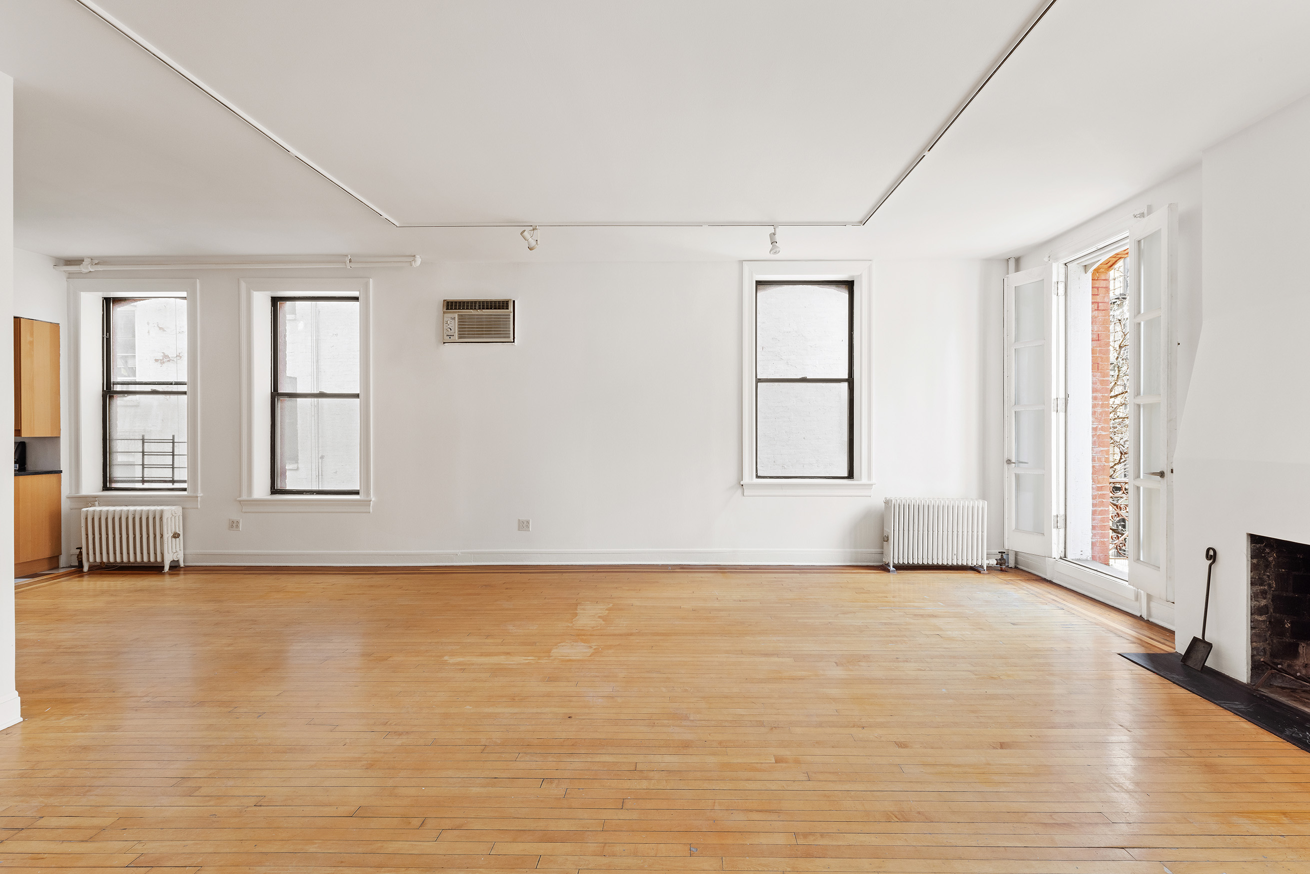 295 East 8th Street, Unit 2/3E Manhattan, NY 10009 - Photo 2 of 23 an empty room with wooden floor and windows