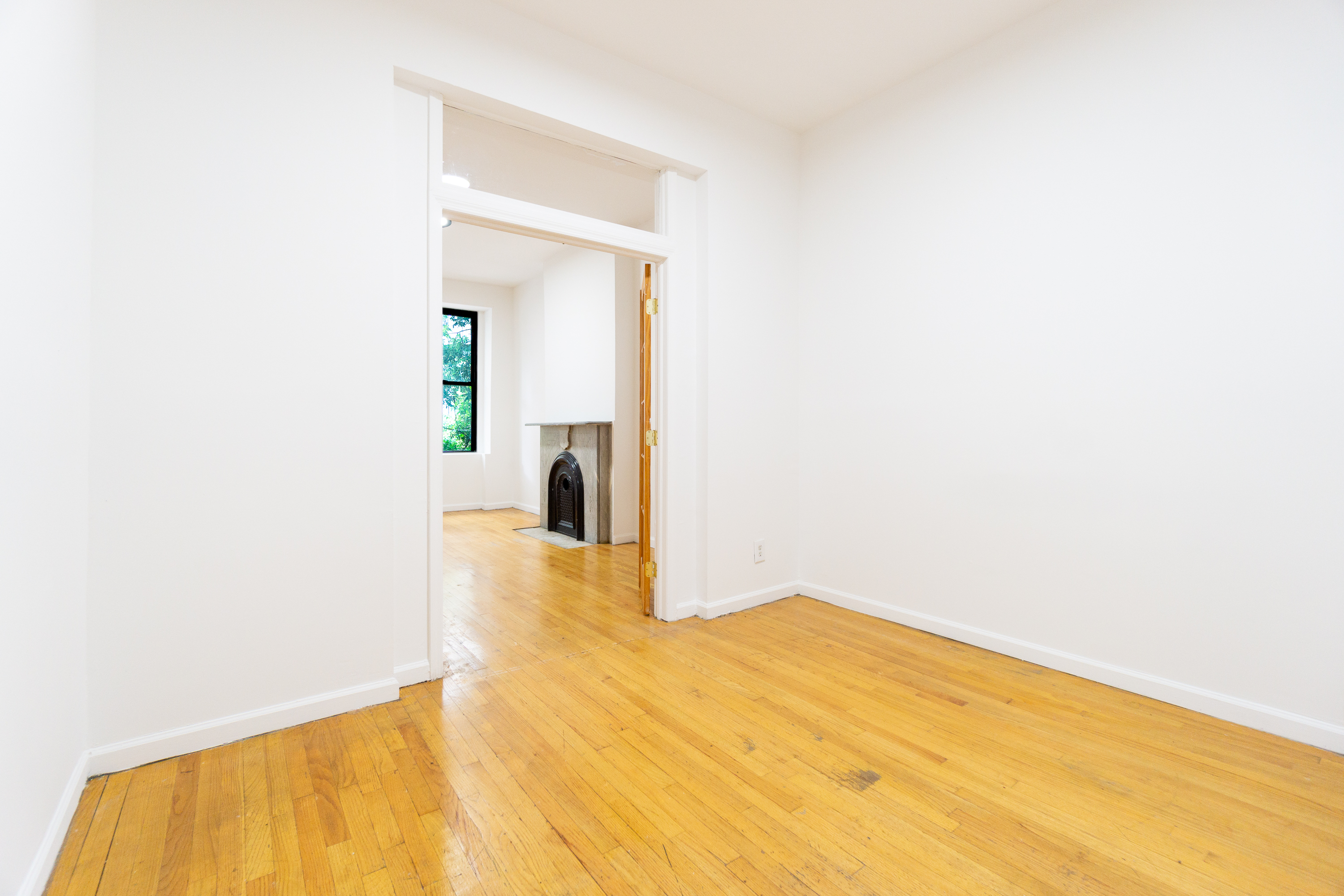 215 East 5th Street, Unit 3 Manhattan, NY 10003 - Photo 6 of 25 a view of a room with wooden floor and a bathroom
