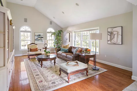a living room with furniture a rug and a large window