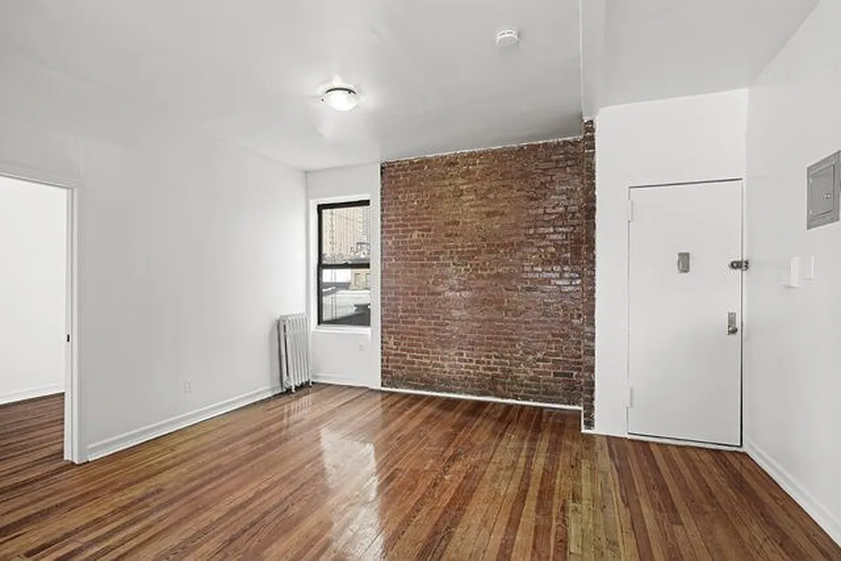 401 West 47th Street, Unit 18 Manhattan, NY 10036 - Photo 1 of 5 wooden floor in an empty room with a window