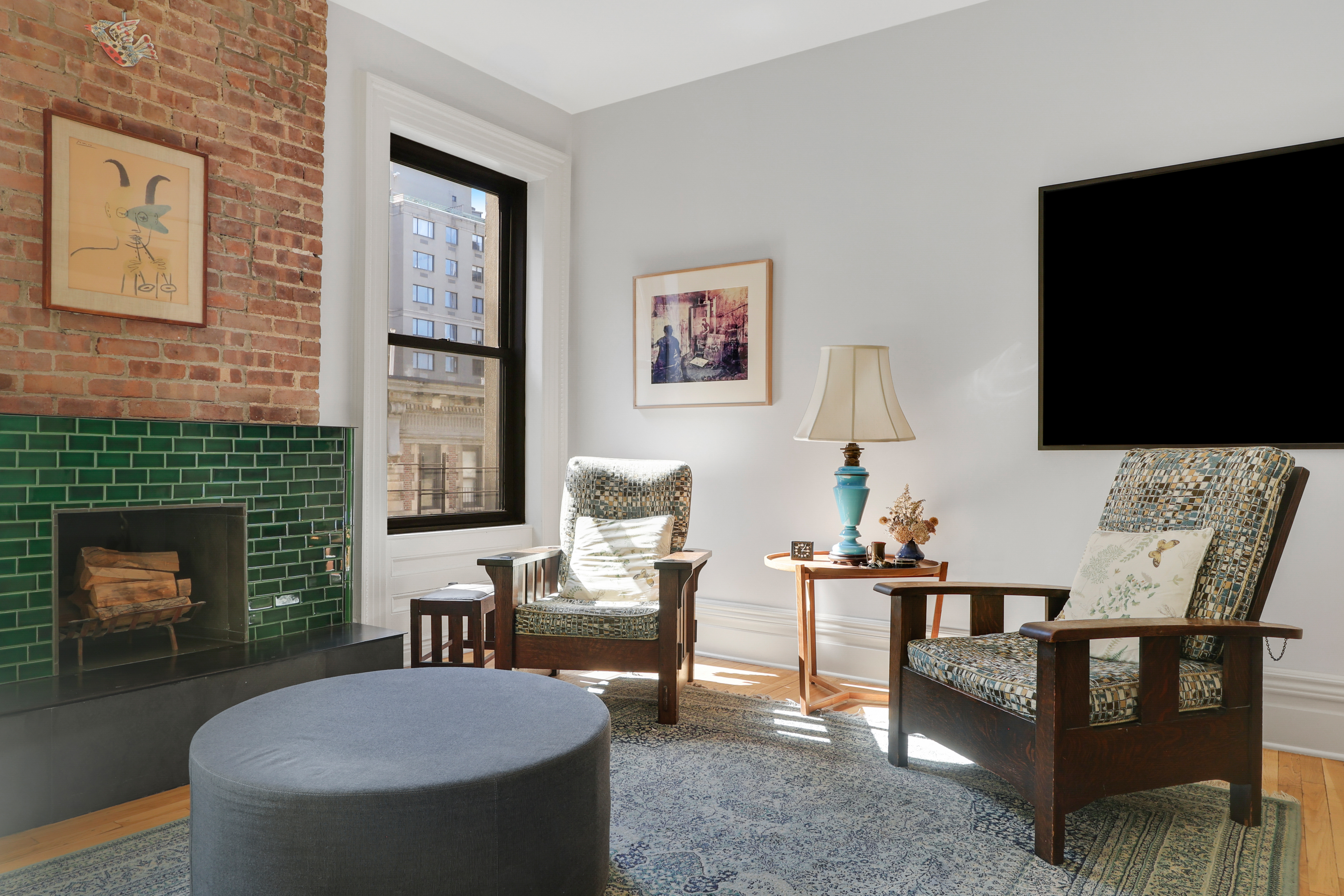 311 West 97th Street, Unit 6E Manhattan, NY 10025 - Photo 5 of 18 a living room with furniture a flat screen tv and a fireplace