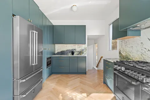 a kitchen with stainless steel appliances granite countertop a refrigerator and a stove