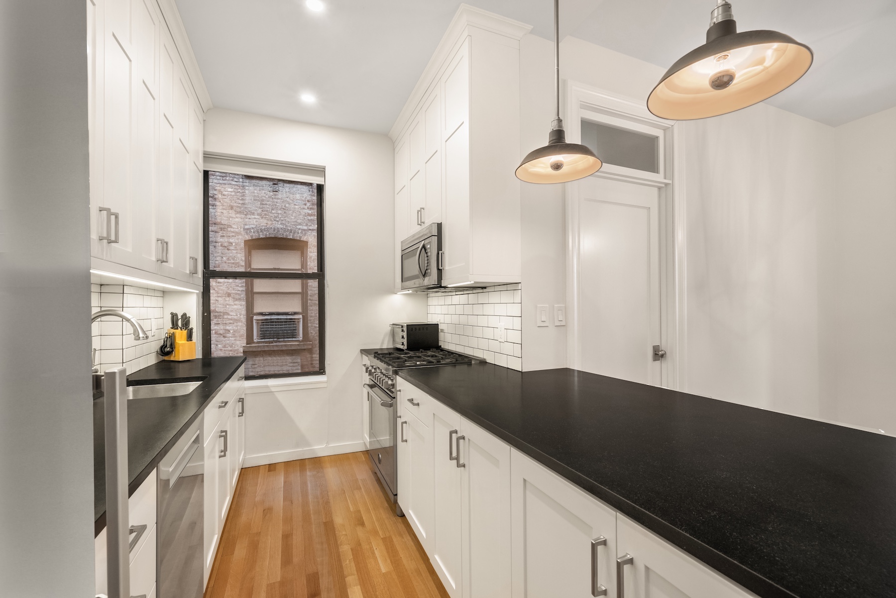 334 West 85th Street, Unit 3A Manhattan, NY 10024 - Photo 3 of 8 a kitchen with granite countertop a stove a sink and a refrigerator