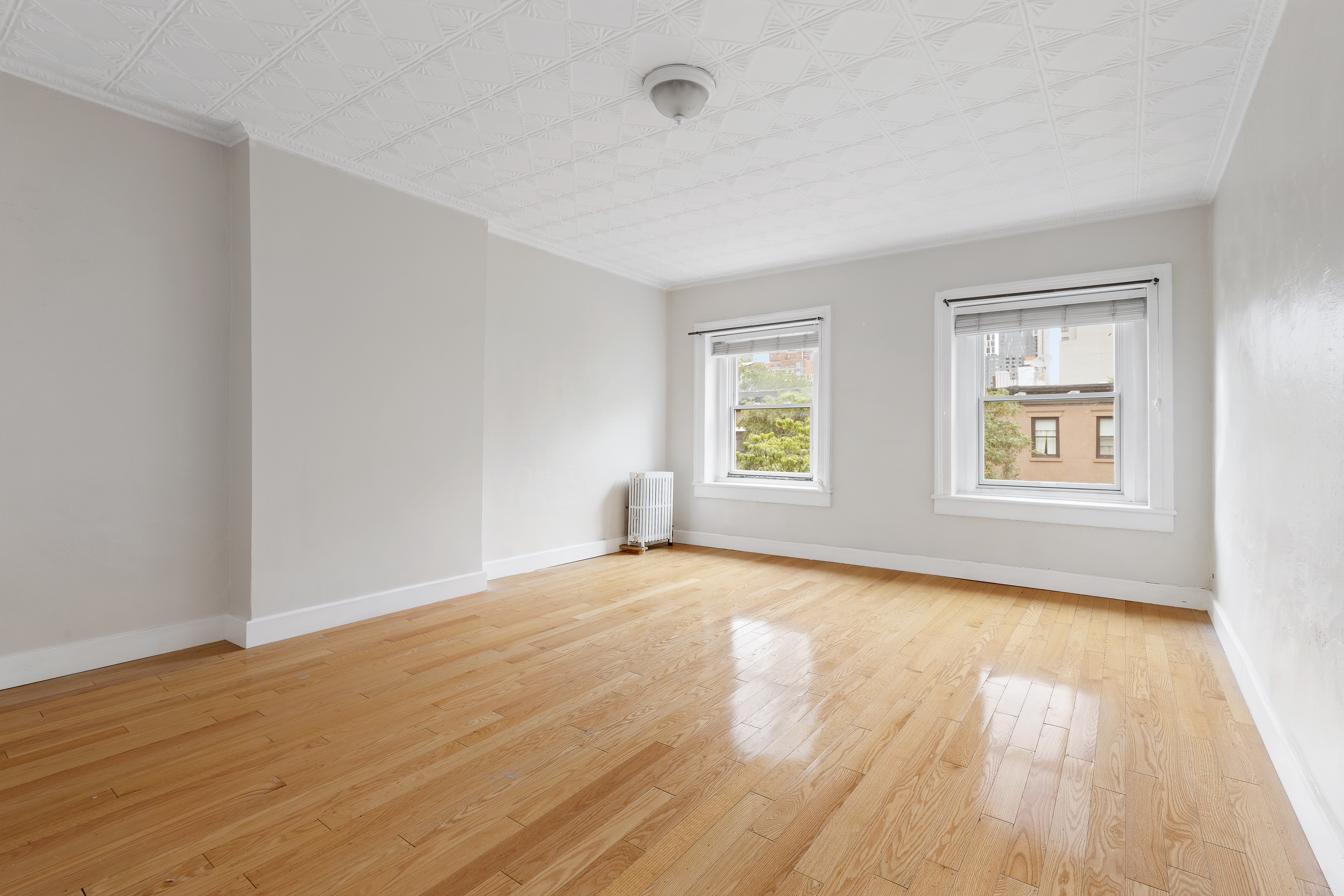 390 Pacific Street, Unit 2 Brooklyn, NY 11217 - Photo 7 of 10 a view of an empty room with wooden floor and a window