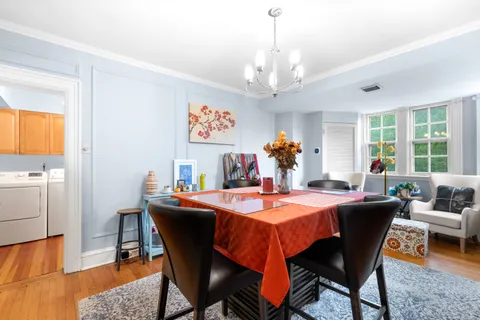a dining room with furniture a large window and wooden floor