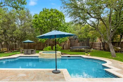 a swimming pool with lawn chair and yard