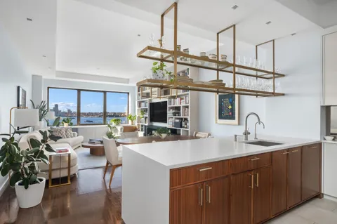 a kitchen with a sink a counter space appliances and cabinets