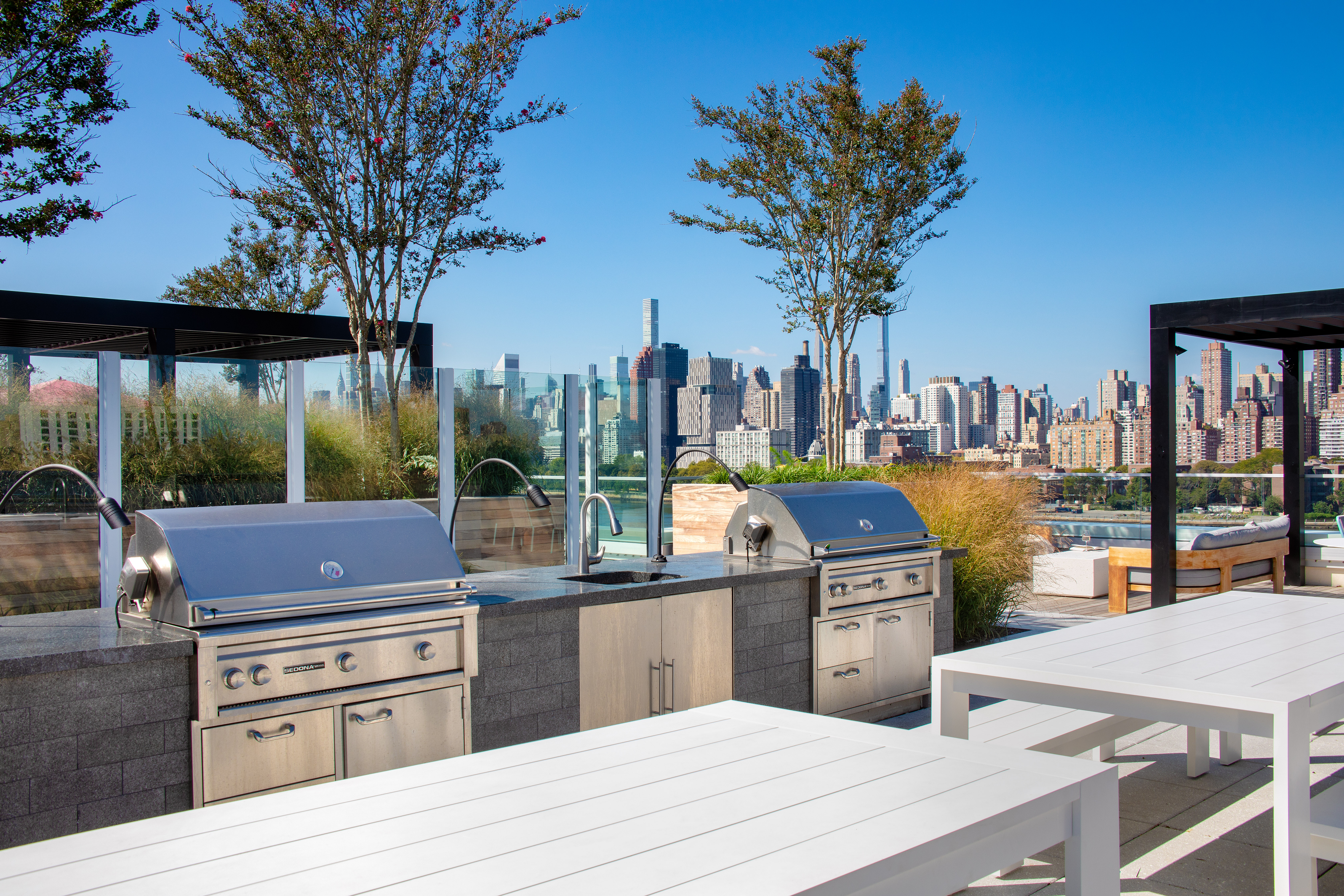 30-77 Vernon Boulevard, Unit 514W Queens, NY 11102 - Photo 9 of 21 a outdoor kitchen with stainless steel appliances kitchen island a stove and a large window