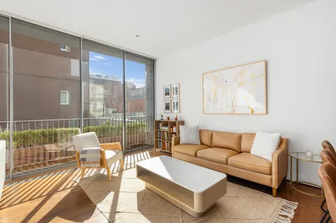 a living room with furniture and a floor to ceiling window