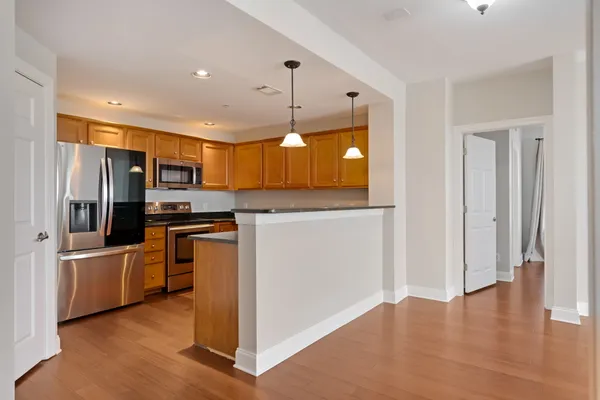 a kitchen with stainless steel appliances granite countertop a refrigerator a stove top oven a sink and dishwasher