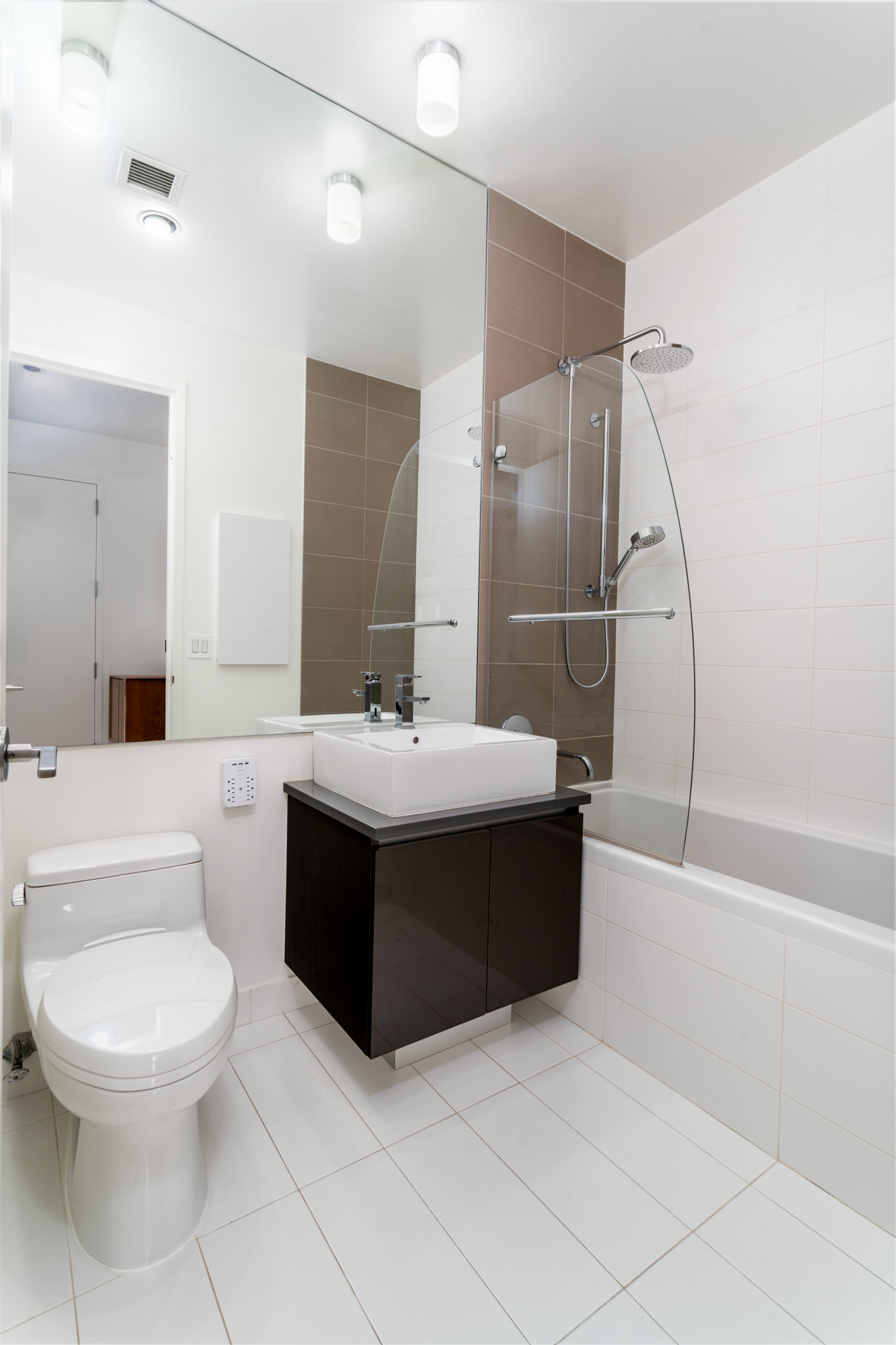 315 Gates Avenue, Unit 4E Brooklyn, NY 11216 - Photo 12 of 17 a bathroom with a bathtub sink mirror vanity and toilet