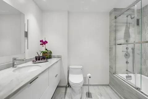a bathroom with a granite countertop sink toilet and shower