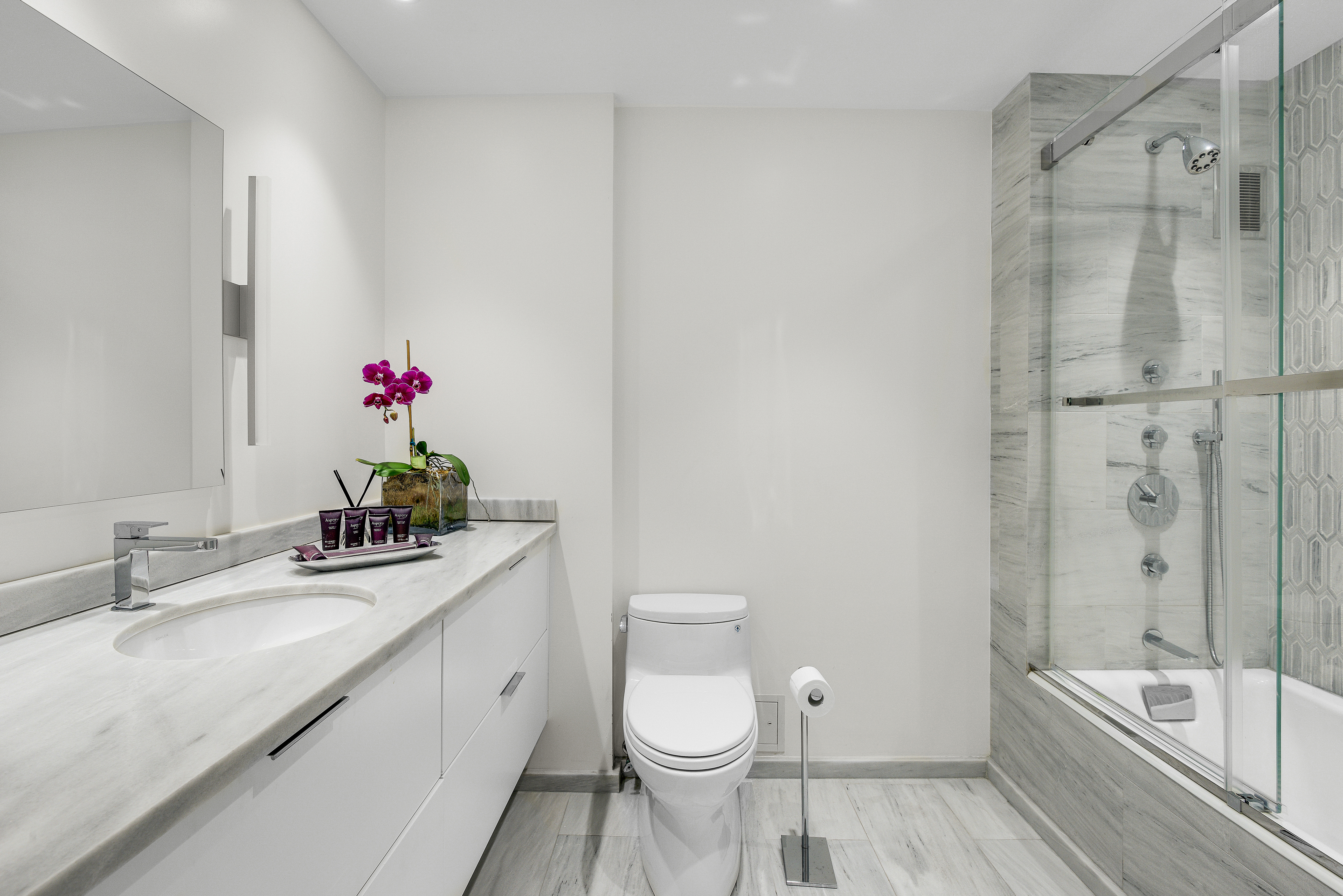 200 Central Park South, Unit 3Q Manhattan, NY 10019 - Photo 12 of 15 a bathroom with a granite countertop sink toilet and shower