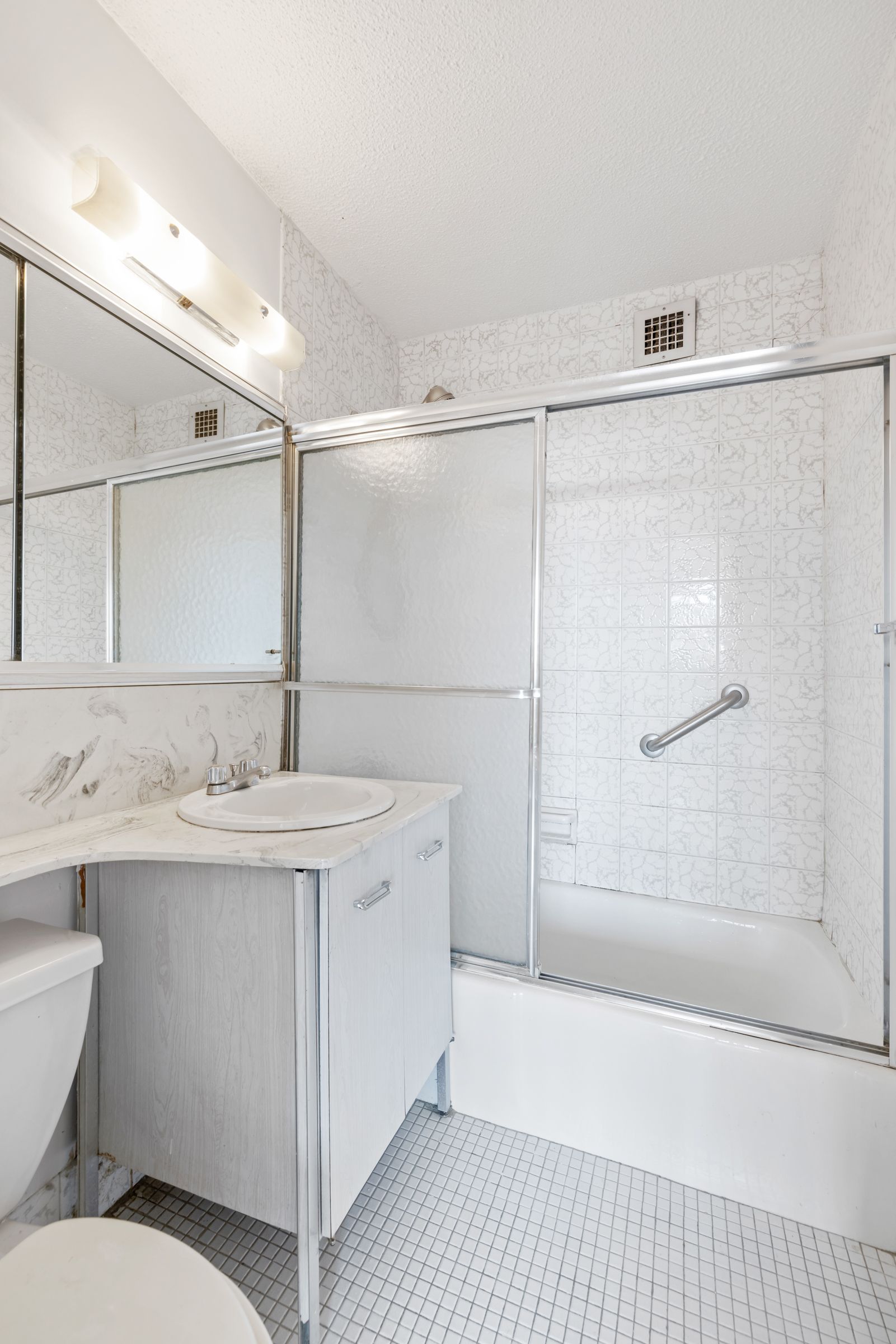201 East 17th Street, Unit 15H Manhattan, NY 10003 - Photo 7 of 24 a bathroom with a sink a toilet and shower