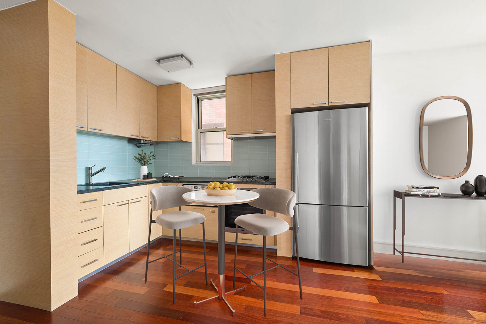 206 East 95th Street, Unit 10B Manhattan, NY 10128 - Photo 3 of 9 a kitchen with stainless steel appliances granite countertop a refrigerator a stove a sink a dining table and chairs with wooden floor