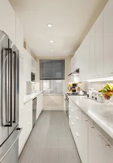 a large white kitchen with cabinets a sink and a stove