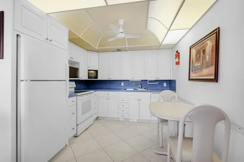 a kitchen with stainless steel appliances a refrigerator sink and white cabinets