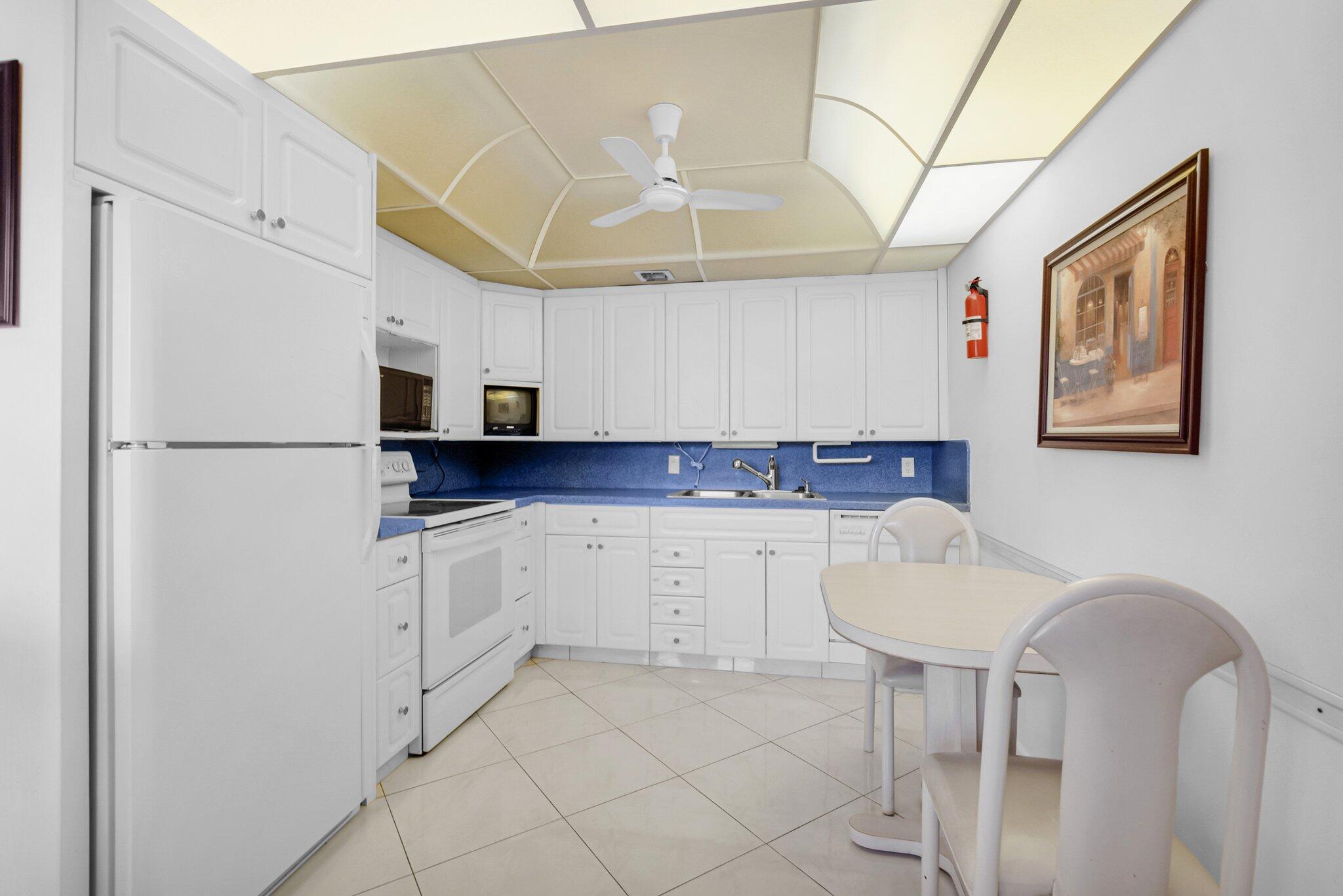 2035 Ainslie C Boca Raton, FL 33434 - Photo 5 of 17 a kitchen with stainless steel appliances a refrigerator sink and white cabinets