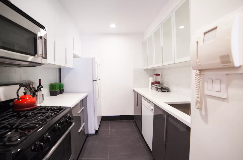 179 Grand Street, Unit 2F Manhattan, NY 10013 - Photo 3 of 13 a kitchen with stainless steel appliances a stove a sink and a refrigerator