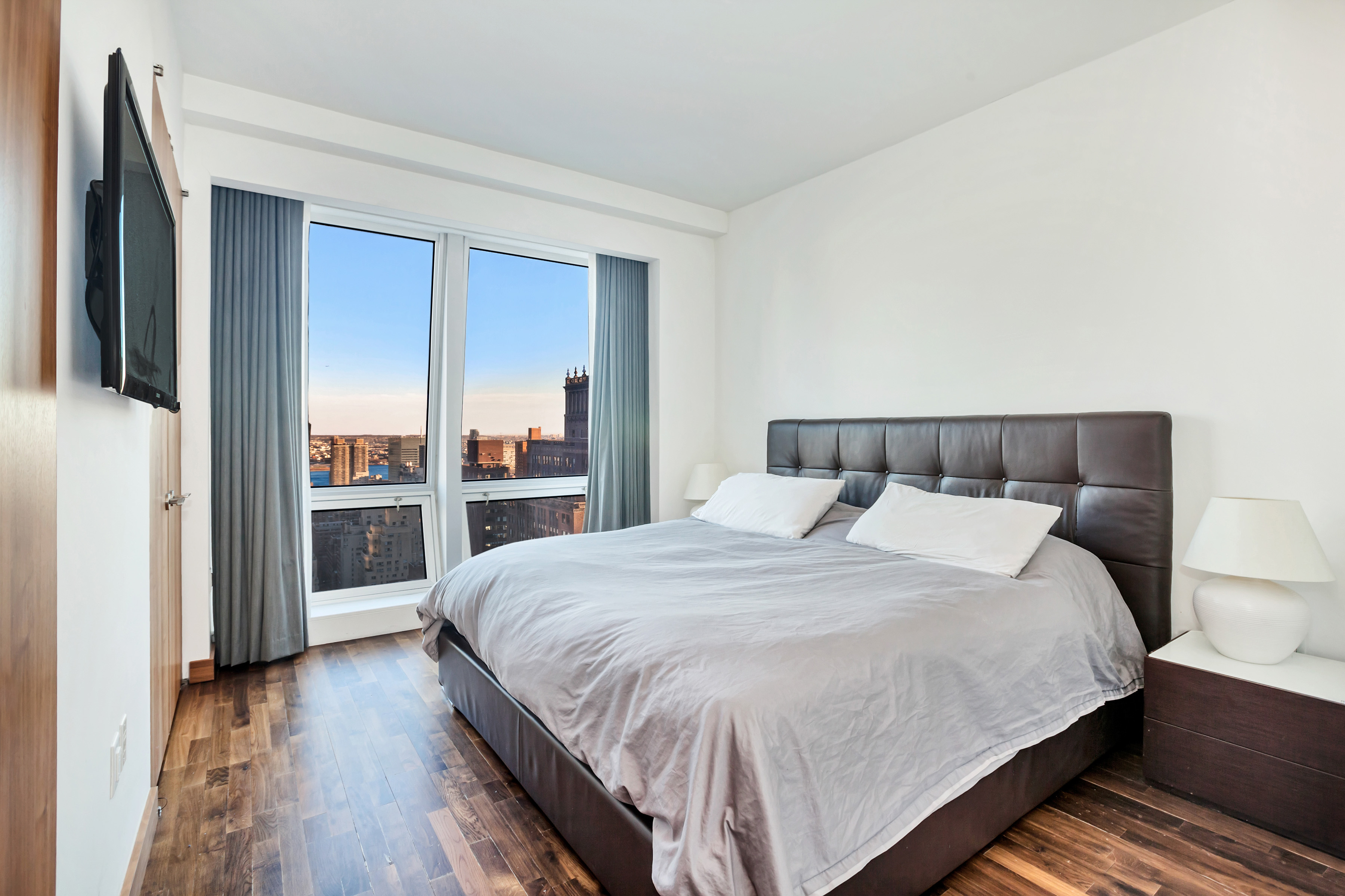 400 5th Avenue, Unit 35C Manhattan, NY 10018 - Photo 4 of 13 a bedroom with a large bed and a book shelf