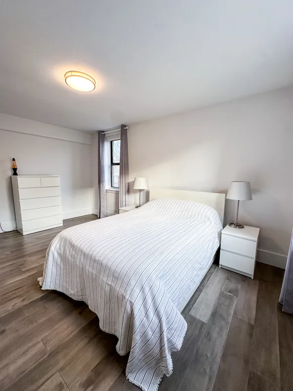 a bedroom with a bed and a night stand