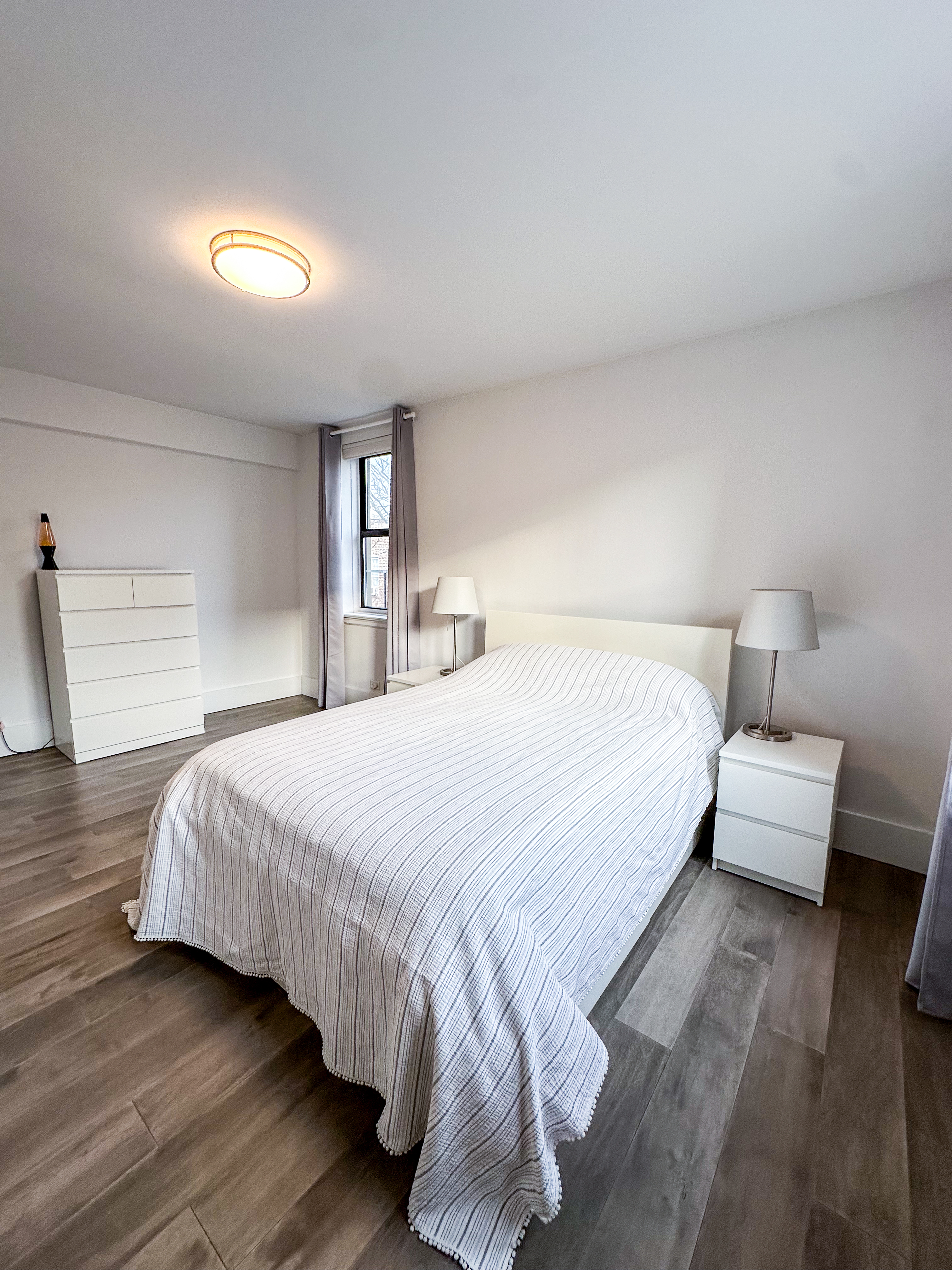 2420 Morris Avenue, Unit 6B Bronx, NY 10468 - Photo 11 of 16 a bedroom with a bed and a night stand