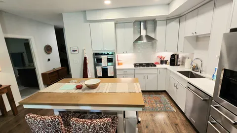 a large kitchen with kitchen island a sink a stove a refrigerator and cabinets