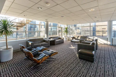 a living room with furniture floor to ceiling window and a table