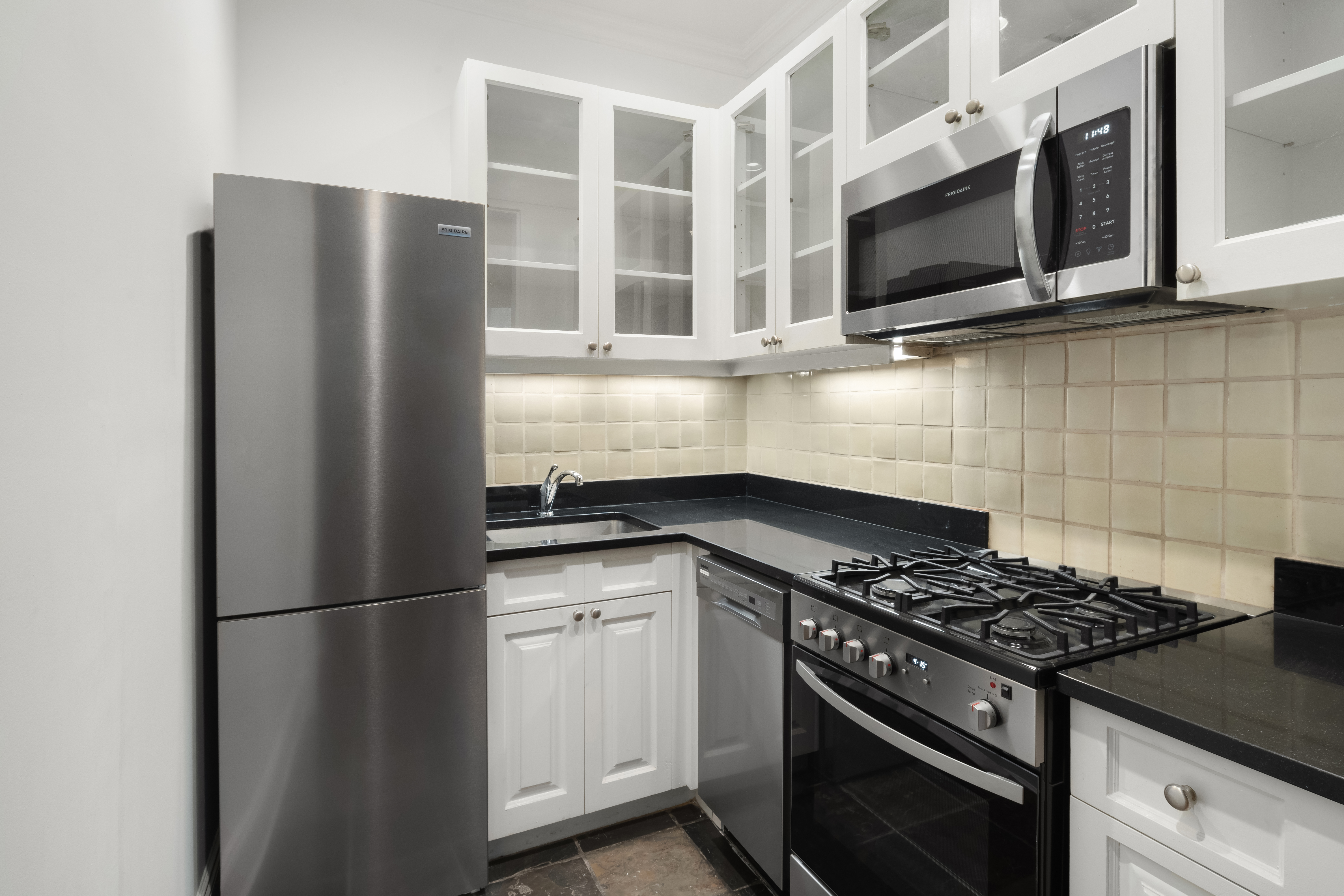 130 West 80th Street, Unit 2R Manhattan, NY 10024 - Photo 5 of 8 a kitchen with stainless steel appliances granite countertop a refrigerator stove and microwave