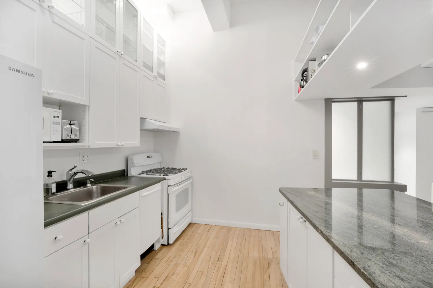 a kitchen with granite countertop a sink and cabinets