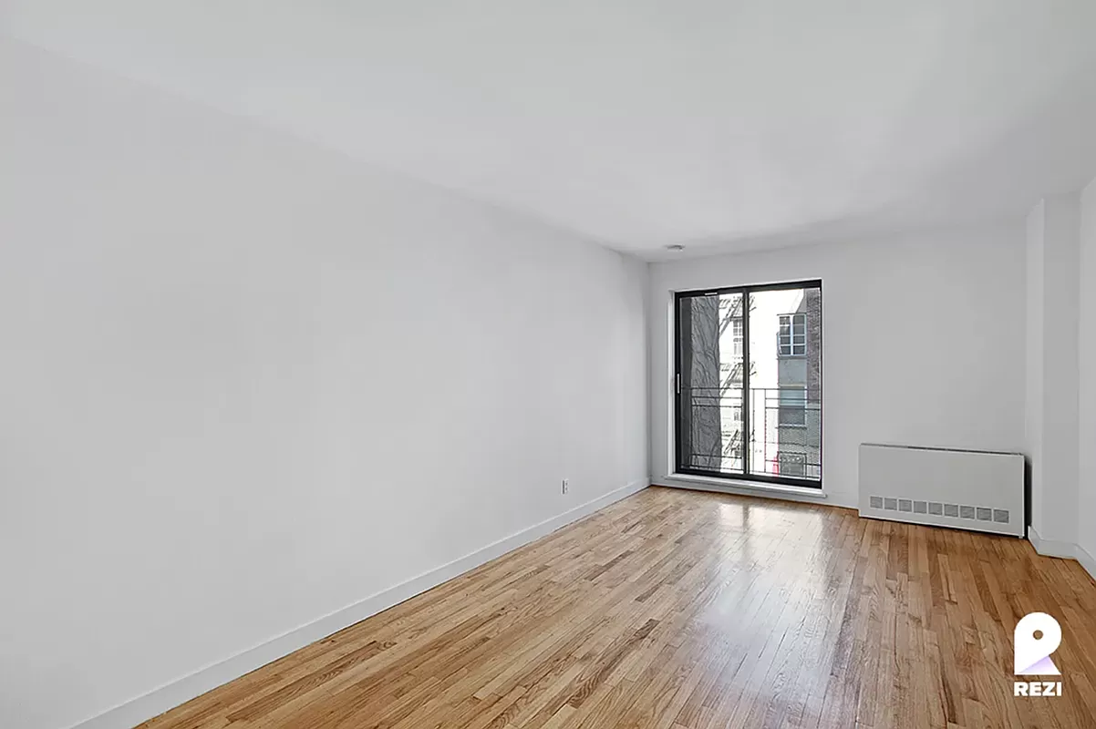 343 East 76th Street, Unit 4C Manhattan, NY 10021 - Photo 6 of 8 wooden floor in an empty room with a window