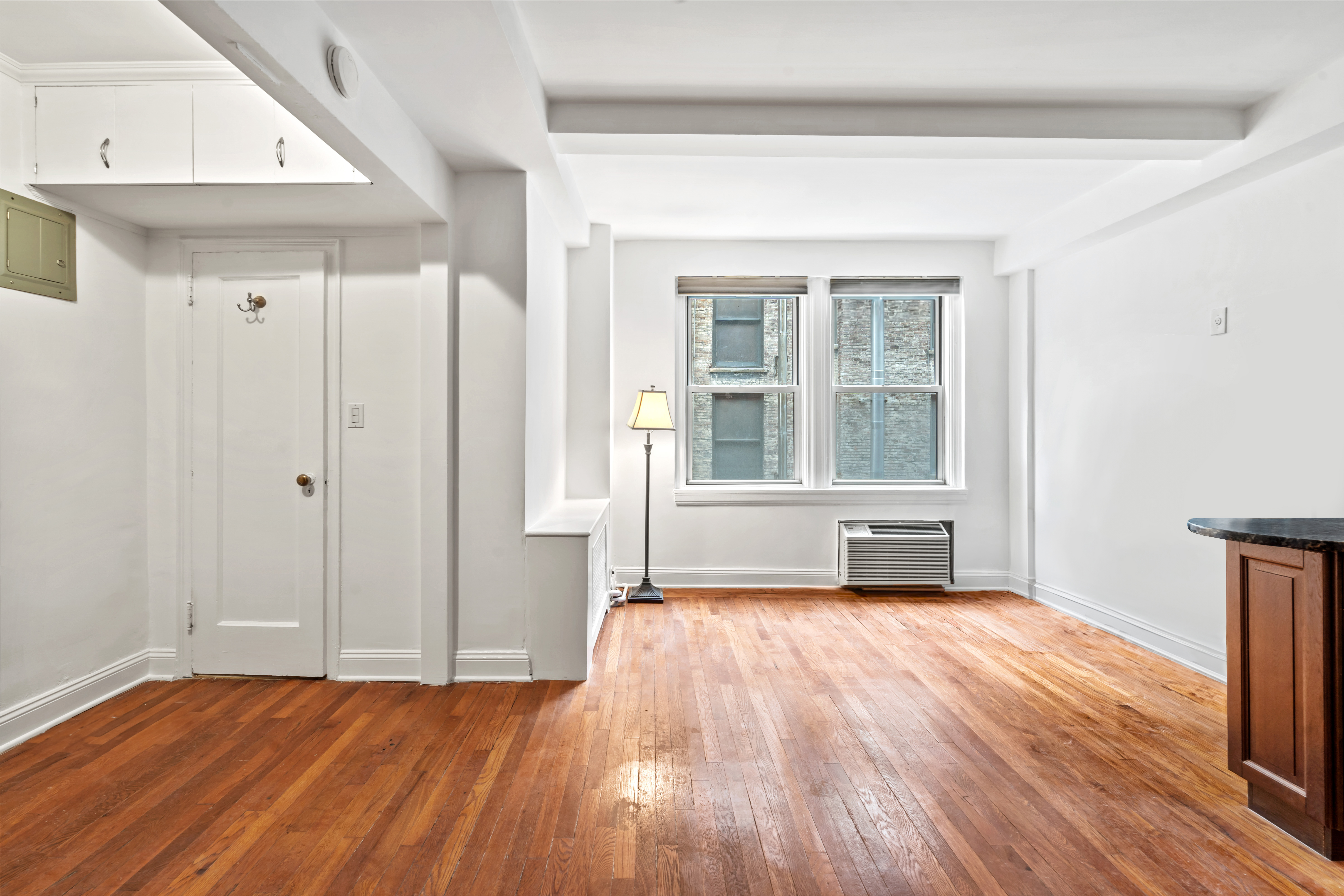 155 East 49th Street, Unit 8C Manhattan, NY 10017 - Photo 3 of 10 a view of an empty room with wooden floor and a window