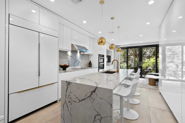 a large kitchen with a large window and stainless steel appliances