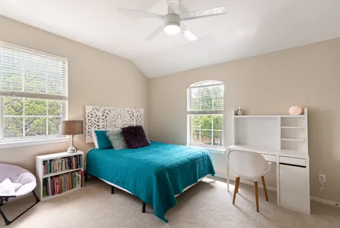 a bedroom with a bed a table and chair