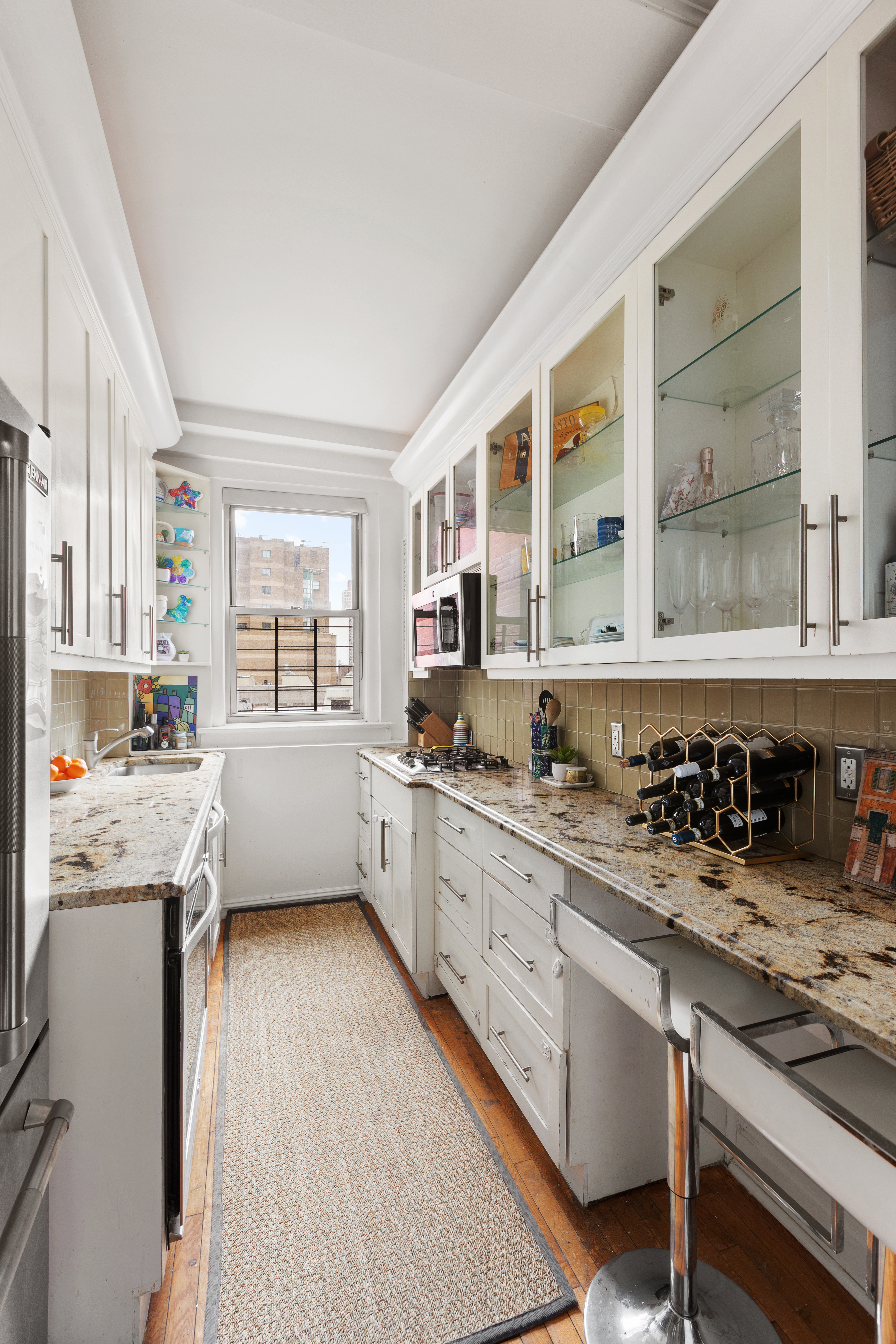 16 East 98th Street, Unit 7F Manhattan, NY 10029 - Photo 2 of 6 a kitchen with stainless steel appliances a sink stove and cabinets
