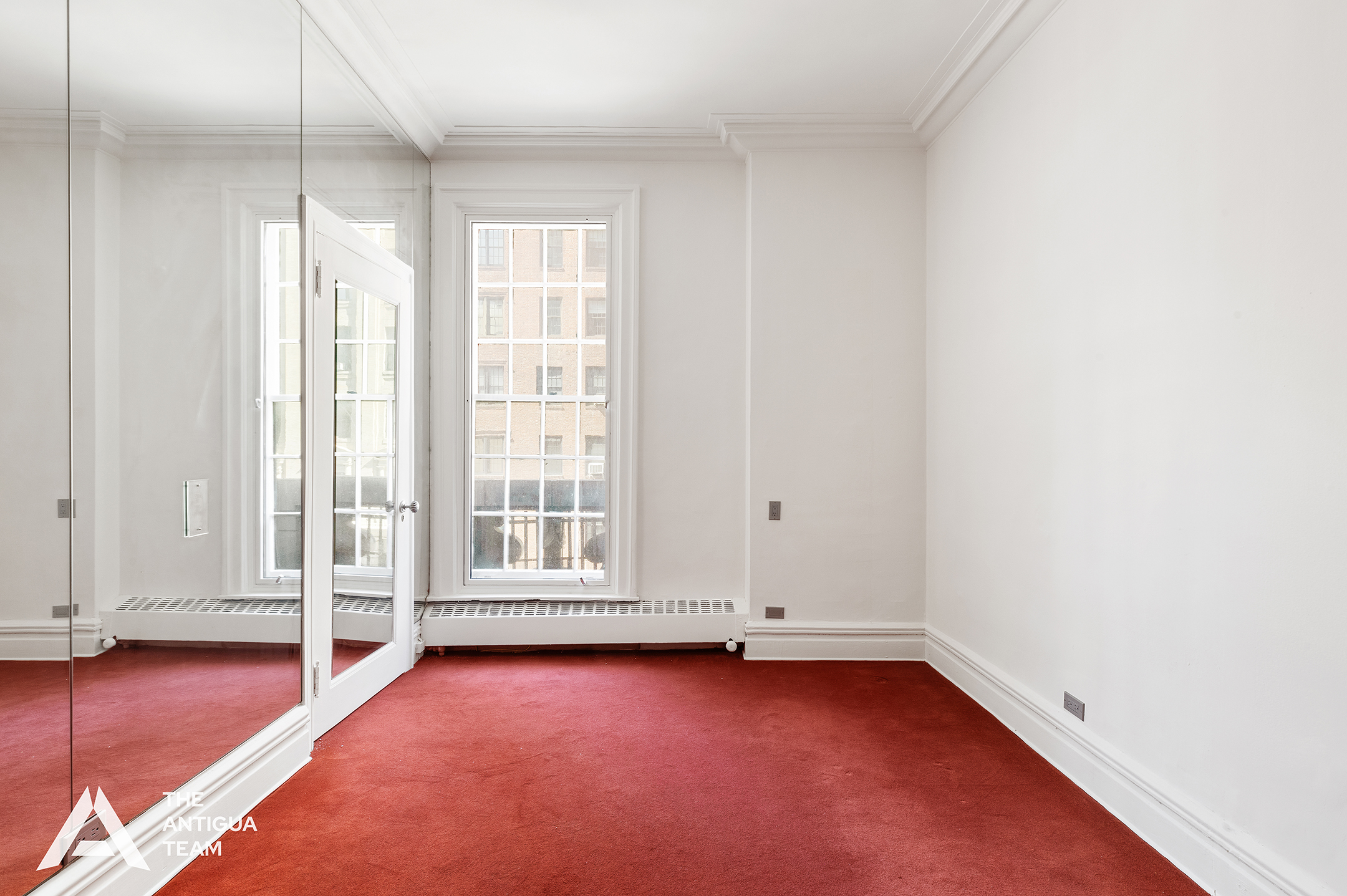 45 East 66th Street, Unit 4W Manhattan, NY 10065 - Photo 15 of 27 an empty room with wooden floor and windows