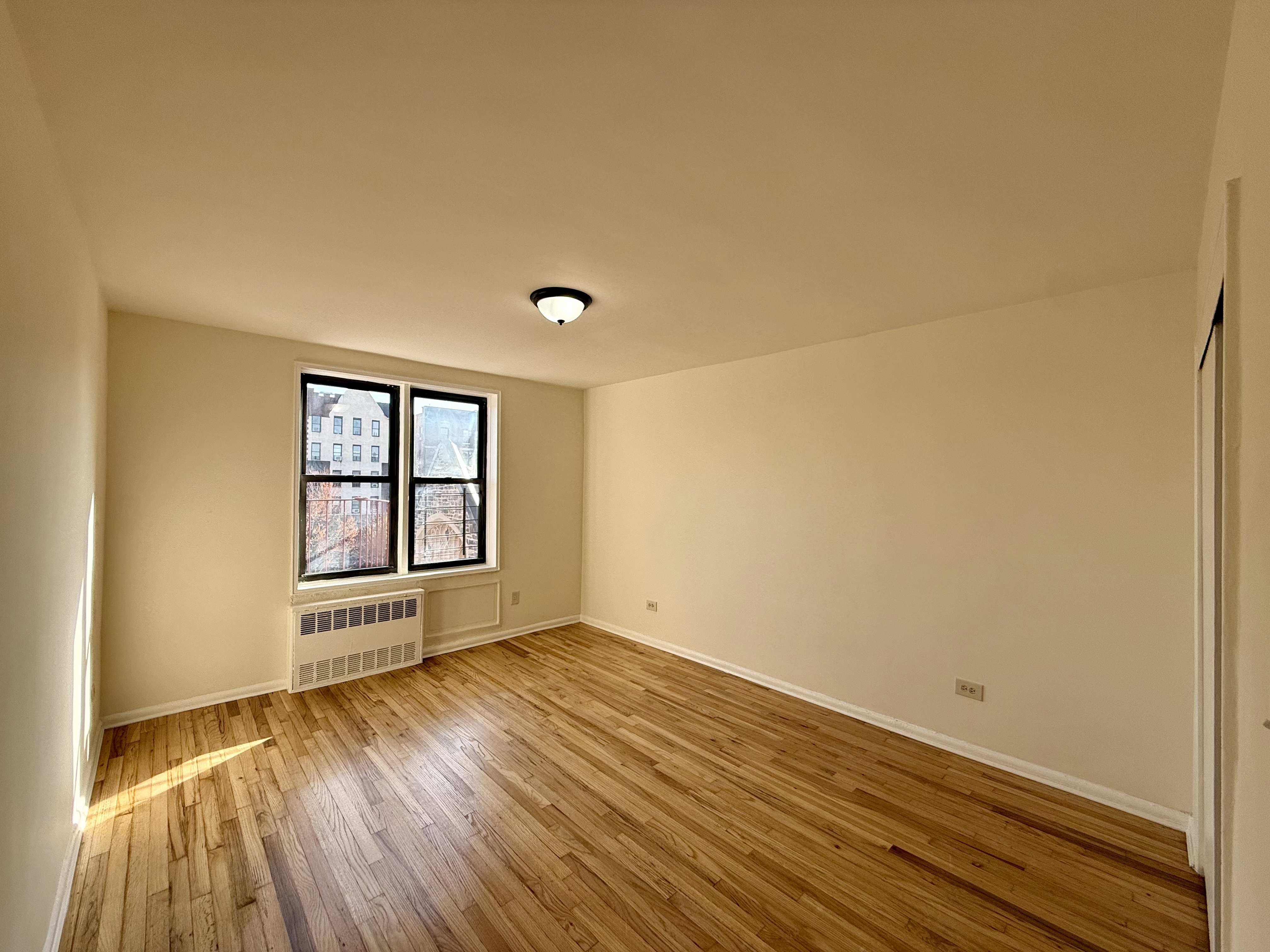 230 73rd Street, Unit 4B Brooklyn, NY 11209 - Photo 7 of 9 an empty room with wooden floor and windows