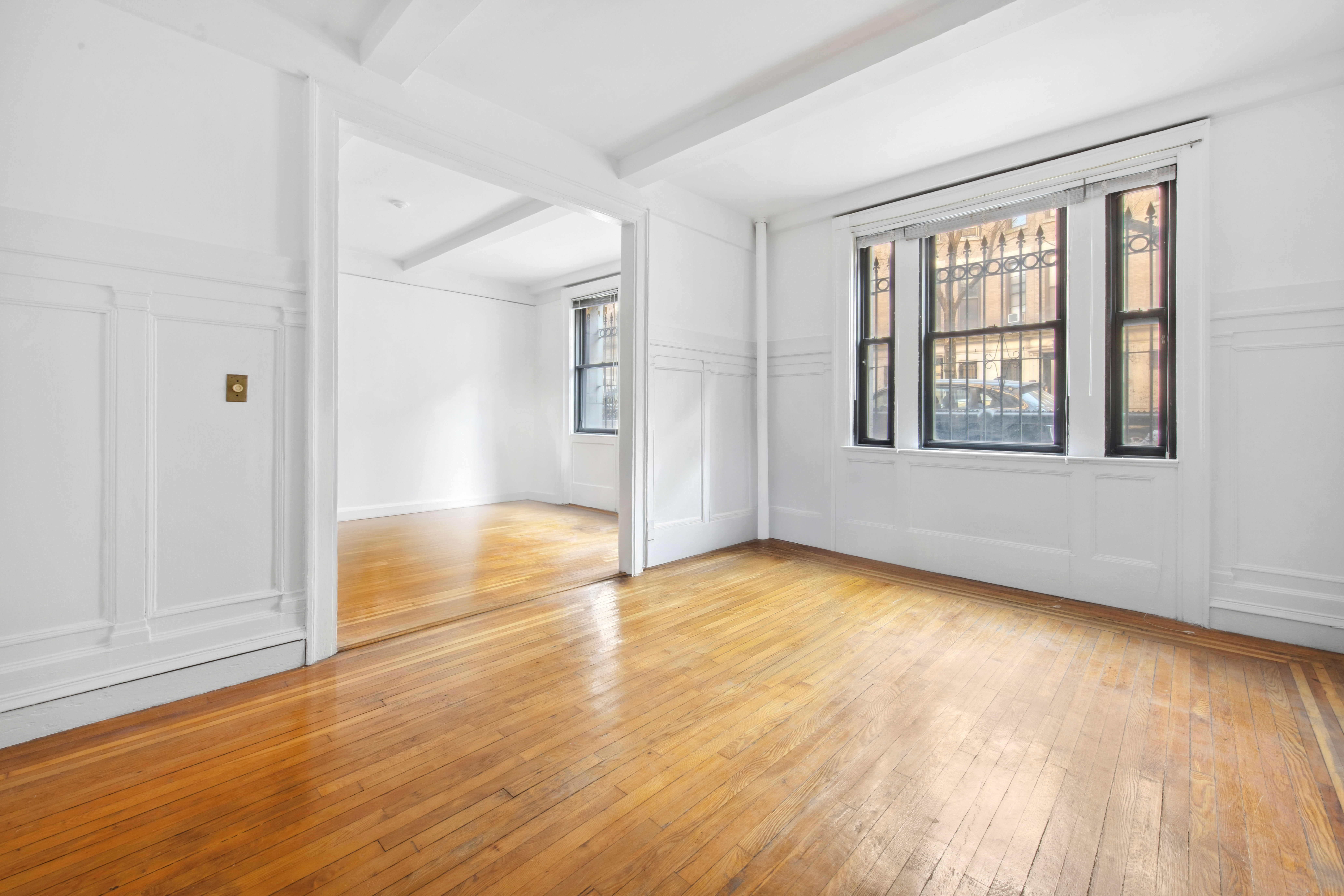 609 West 114th Street, Unit 2 Manhattan, NY 10025 - Photo 4 of 16 a view of an empty room with wooden floor and a window