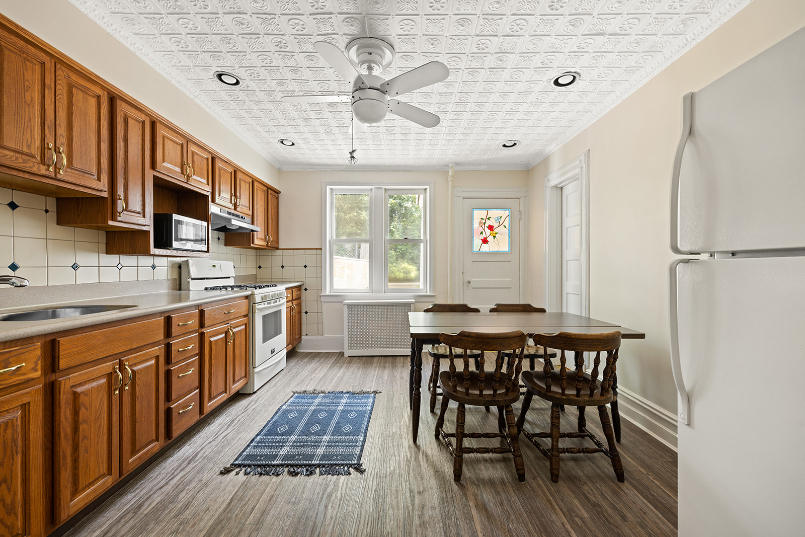 273 Windsor Place Brooklyn, NY 11218 - Photo 11 of 29 a kitchen with stainless steel appliances a table chairs refrigerator and cabinets