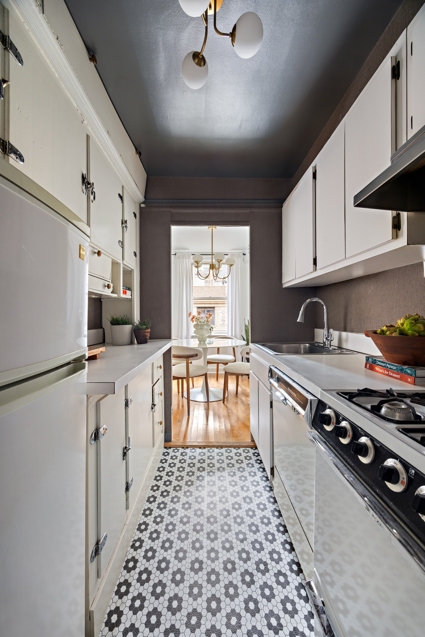 155 East 49th Street, Unit 10A Manhattan, NY 10017 - Photo 7 of 16 a kitchen with granite countertop a refrigerator stove sink and cabinets