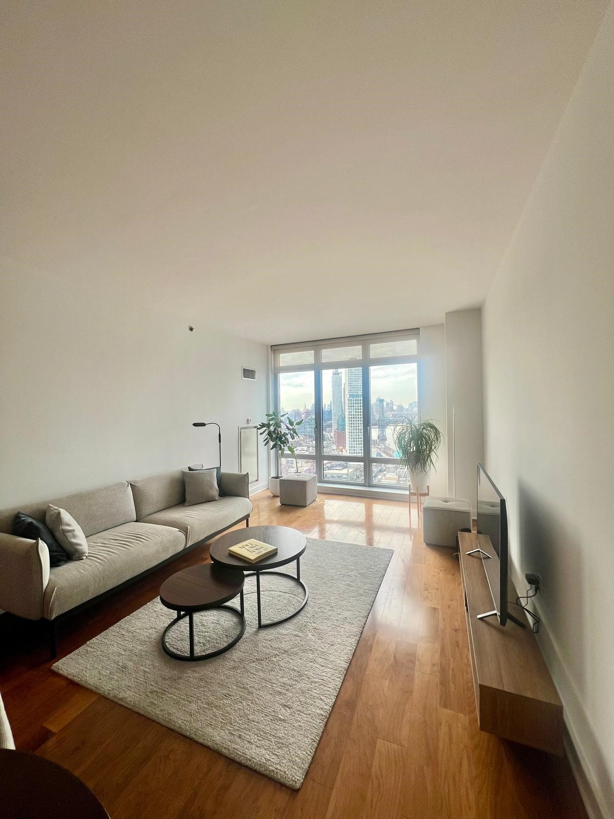 2 Northside Piers, Unit 26C Brooklyn, NY 11249 - Photo 3 of 21 a living room with furniture and a wooden floor