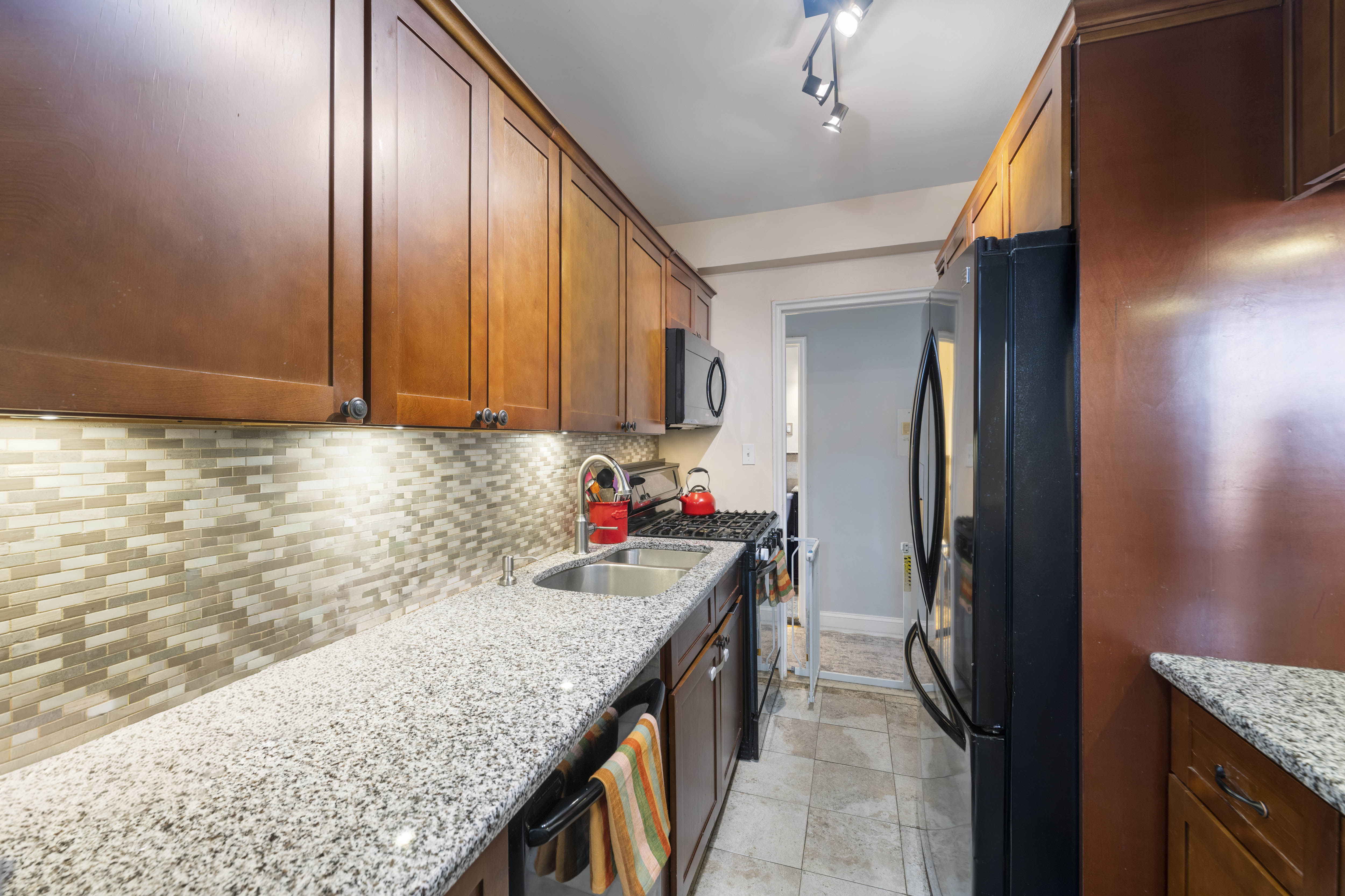 3475 Greystone Avenue, Unit 7B Bronx, NY 10463 - Photo 6 of 13 a kitchen with stainless steel appliances granite countertop a sink refrigerator and cabinets