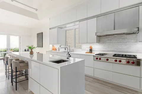 a kitchen with white cabinets and appliances