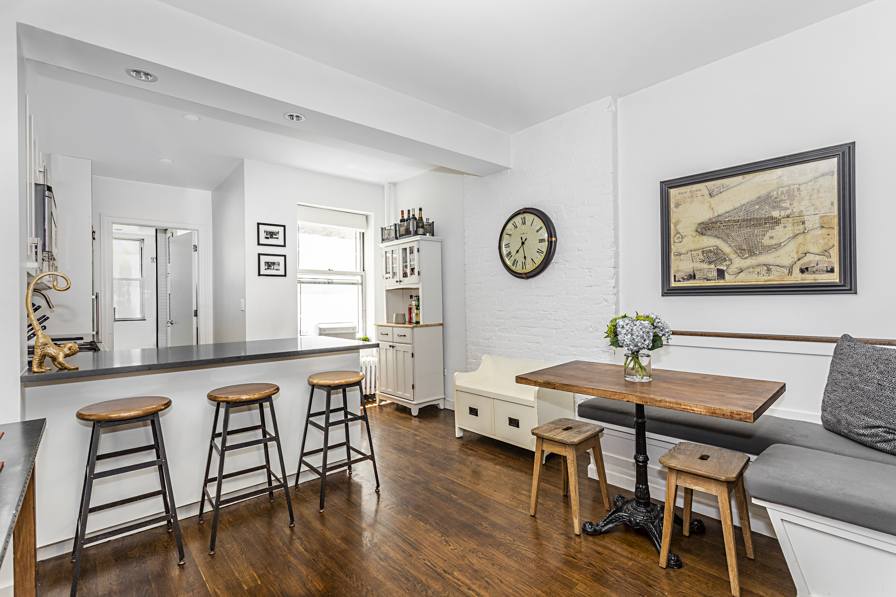 236 East 6th Street, Unit 2W Manhattan, NY 10003 - Photo 2 of 7 a view of a dining room and livingroom with furniture wooden floor and a clock