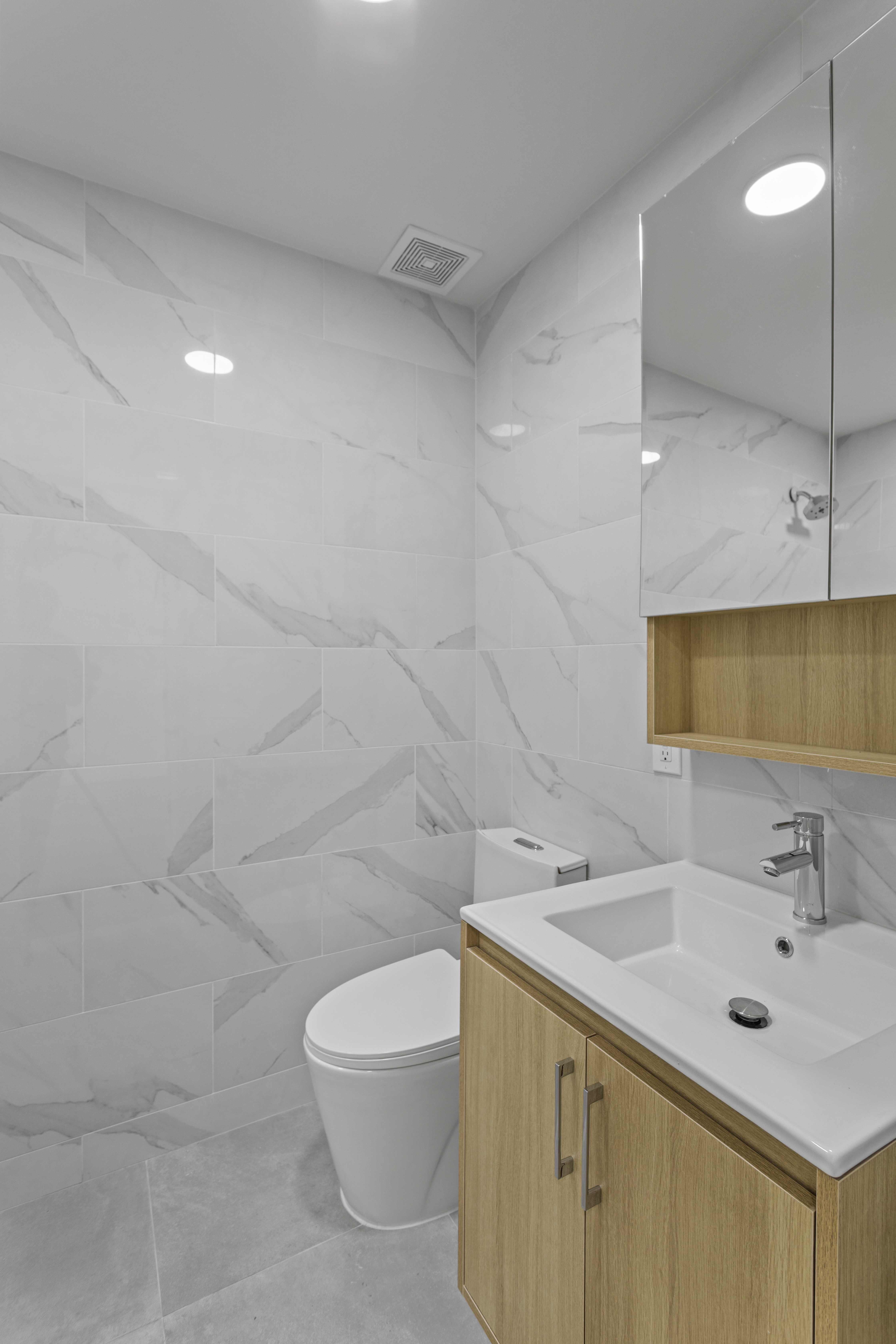 3112 Emmons Avenue, Unit 3120A-2 Brooklyn, NY 11235 - Photo 9 of 14 a bathroom with a sink a toilet and a mirror