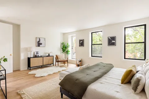 a bedroom with a bed and wooden floor