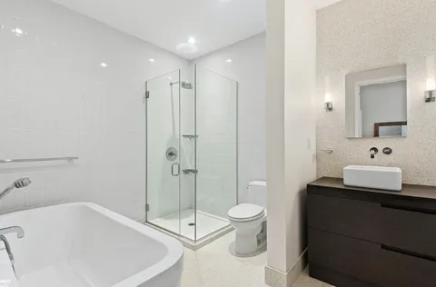 a bathroom with a bathtub shower sink and toilet